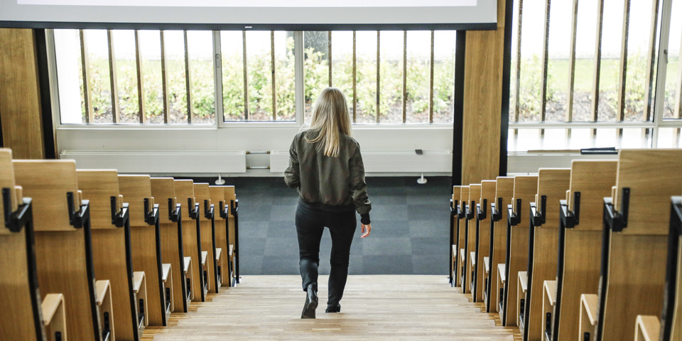 Kvinde går ned af trappen i auditorium
