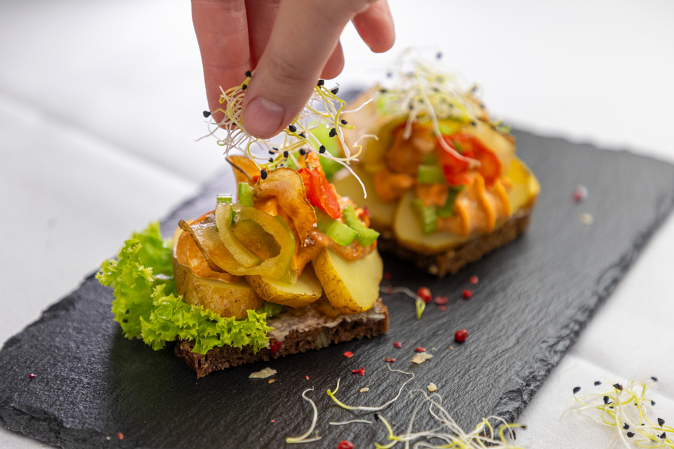 Kartoffelmad anrettet med rød mayonnaise, bladselleri og porrespirer