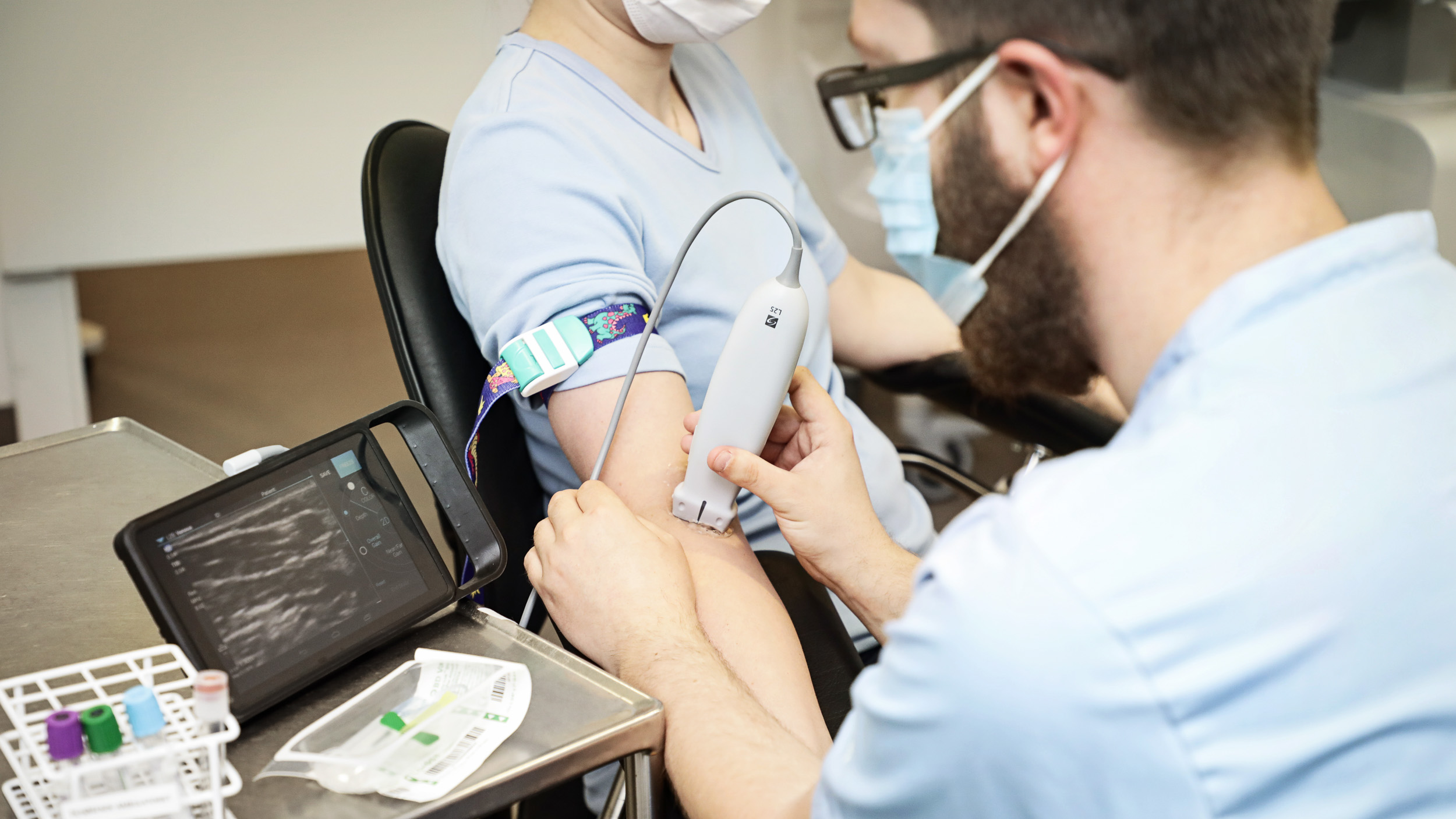 Sygeplejerske bruger ultralydsscanner på patients arm