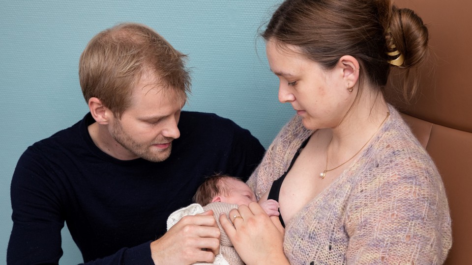 Familie med far og mor og baby, der ammes