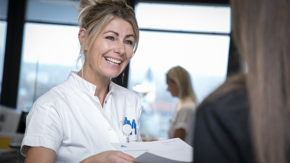 Sekretær byder patient velkommen