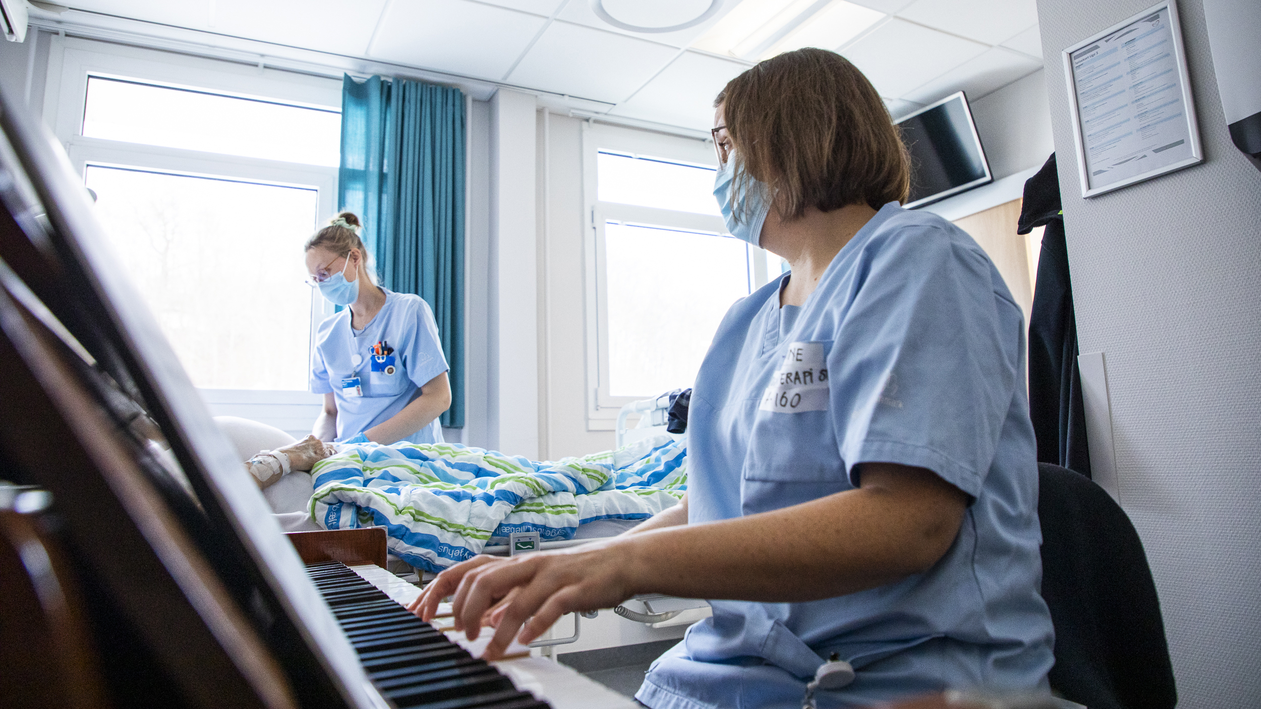 Patienten lytter i baggrunden, mens Line Nikolajsen spiller på klaveret,