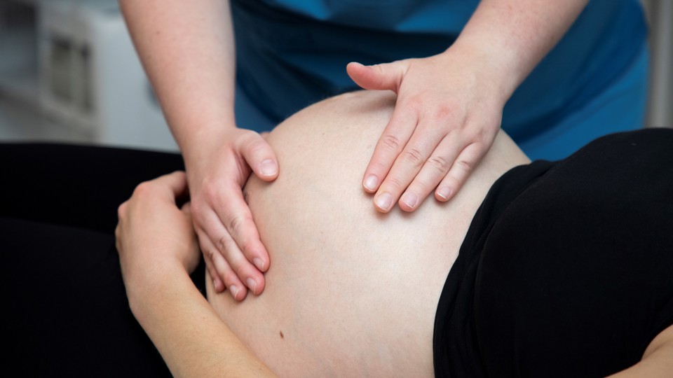 Jordmoder mærker på den gravides mave