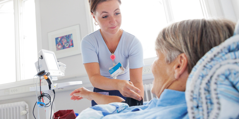 Sygeplejerske plejer patient.