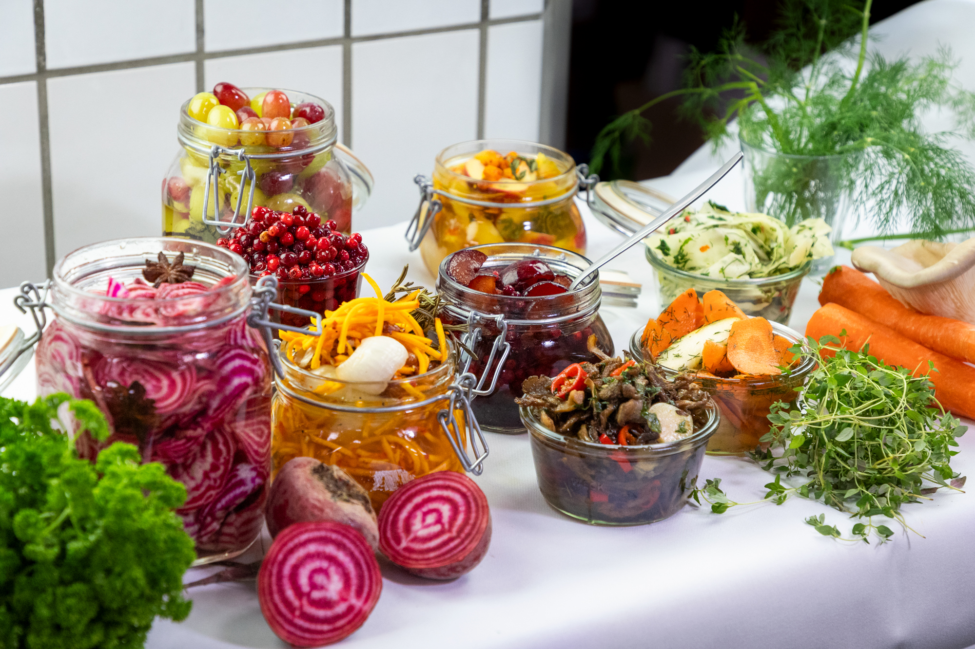 Syltede grønsager i glas på et bord
