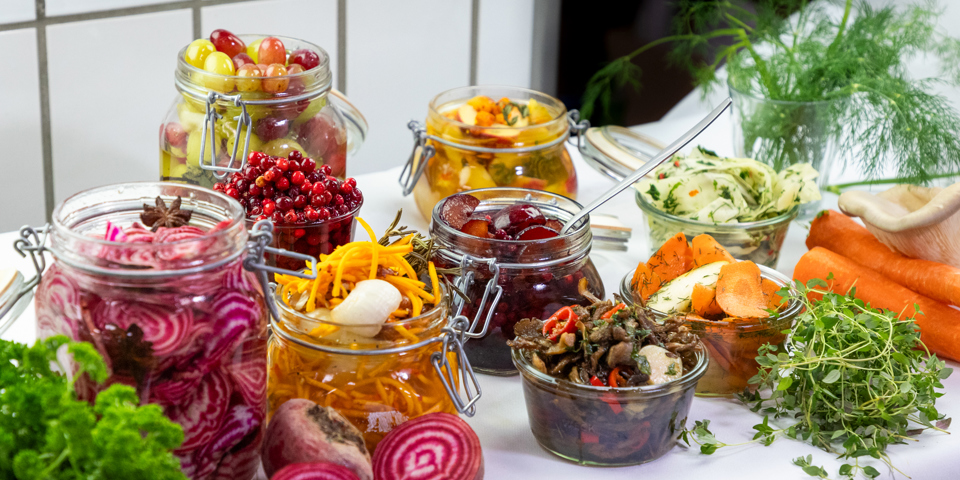 Syltede grønsager i glas på et bord