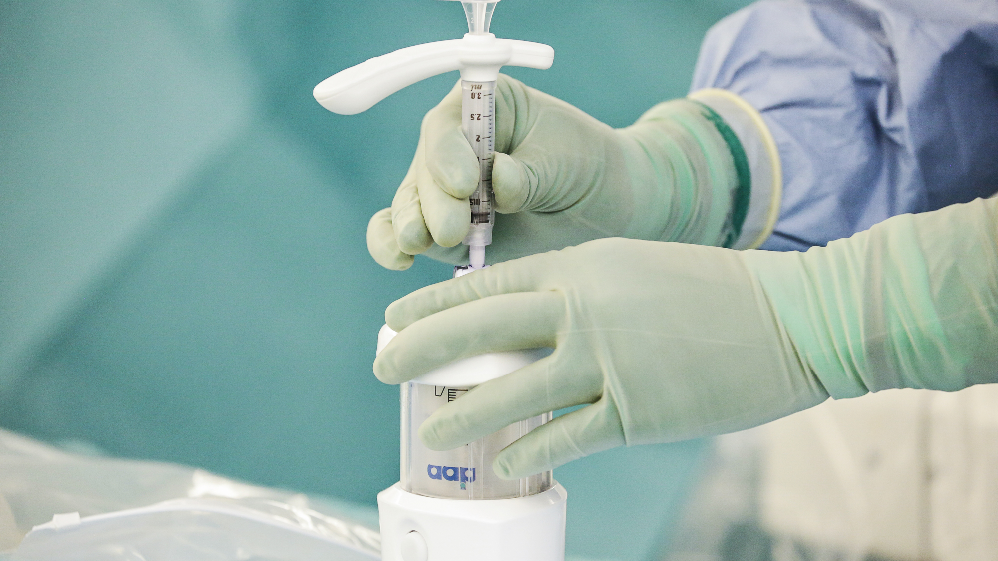 Hænder fylder cement i kanyle