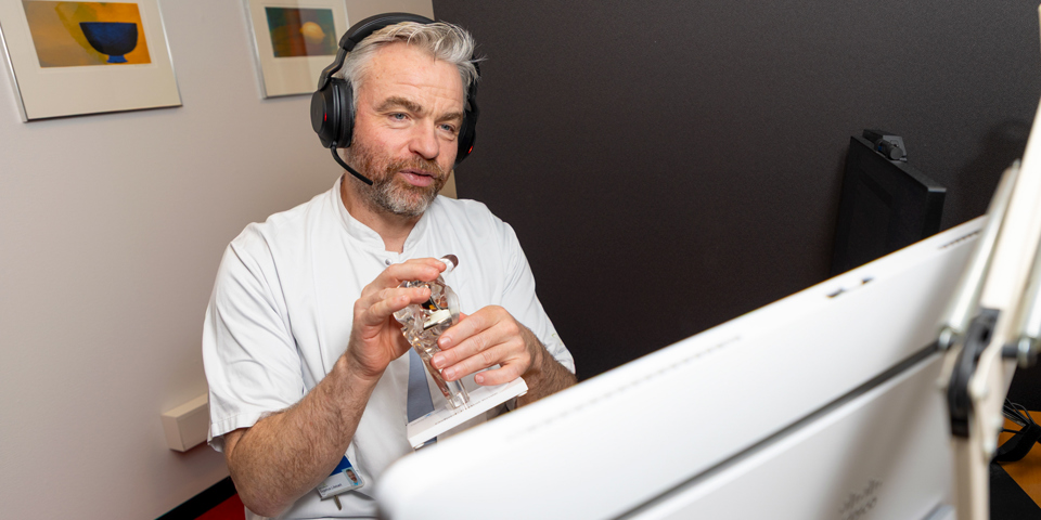 Lasse Enkebølle Rasmussen med headset på hovedet foran skærm