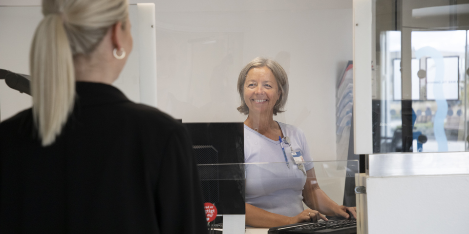 Sekretær modtager patient i Akutafdelingens reception