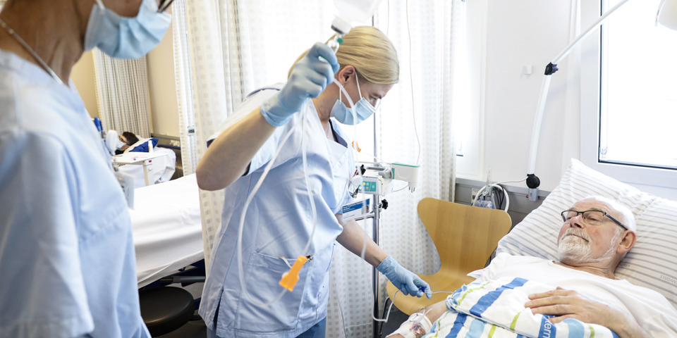 Patient modtager behandling af to sygeplejersker