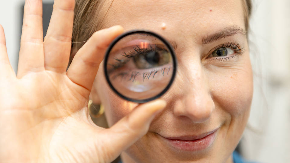 Kvinde holder linse.