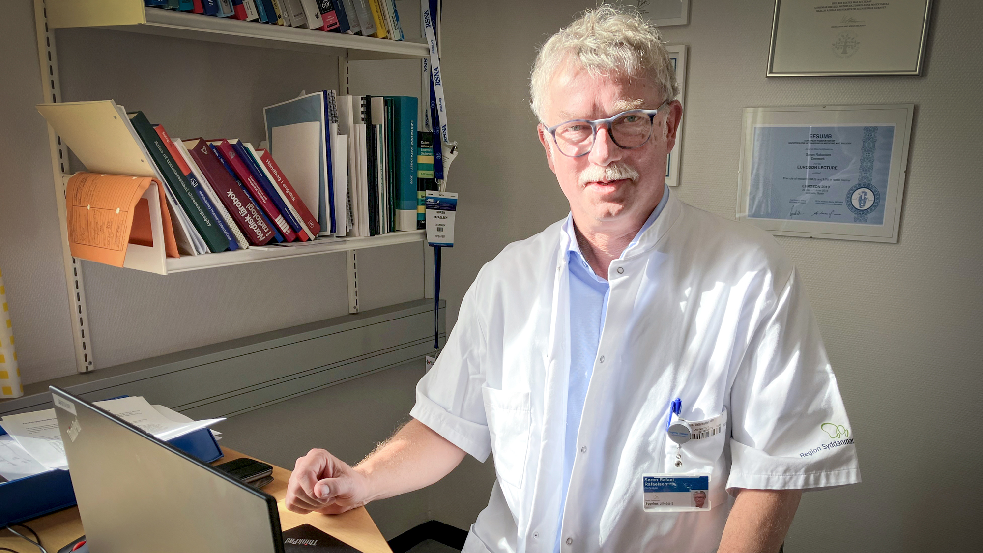 Læge sidder bag computerskærm