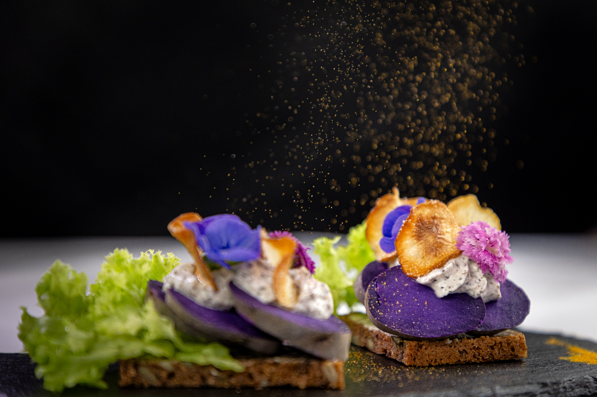 Kartoffelmad med blå kartoffel anrettet med mayonnaise og spiseblomst