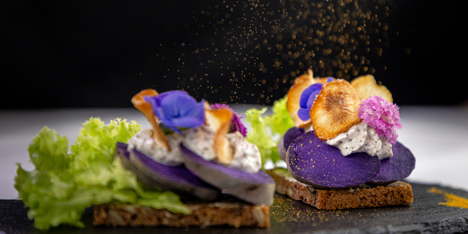 Kartoffelmad med blå kartoffel anrettet med mayonnaise og spiseblomst