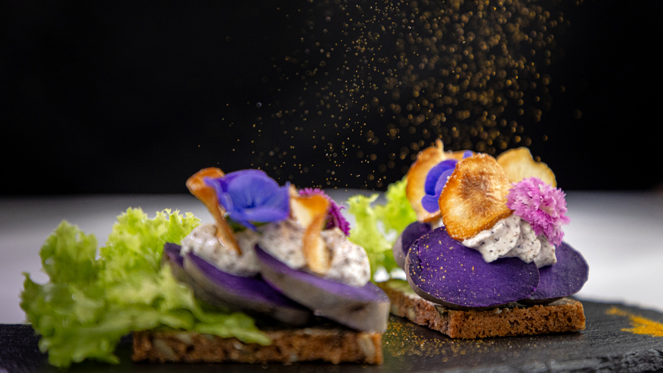 Kartoffelmad med blå kartoffel anrettet med mayonnaise og spiseblomst