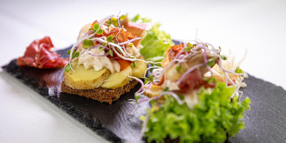 Kartoffelmad anrettet med peberrodspread, serranoskinke og kantarel