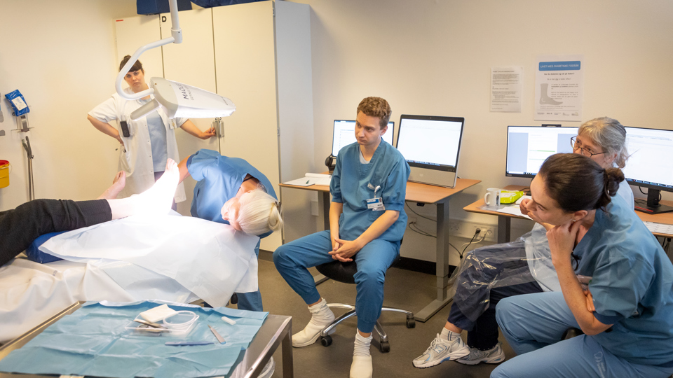 Læge undersøger fod.