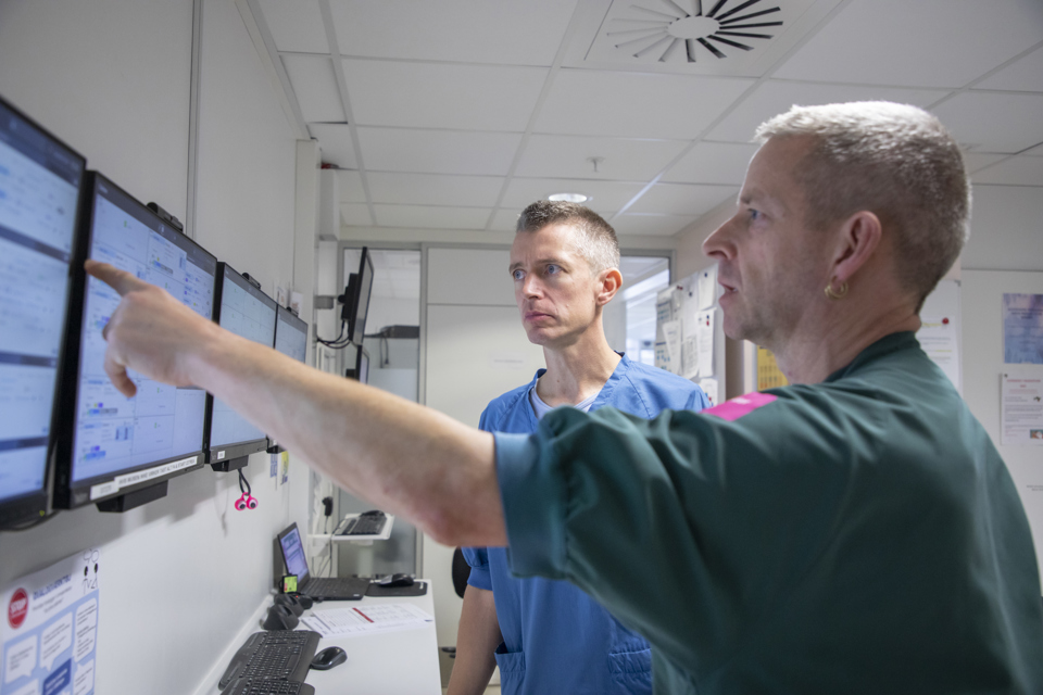 Læge og zoneleder peger på skærm