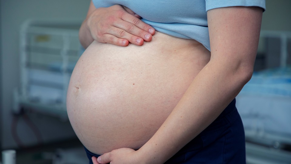 Kvinde mærker på sin gravide mave