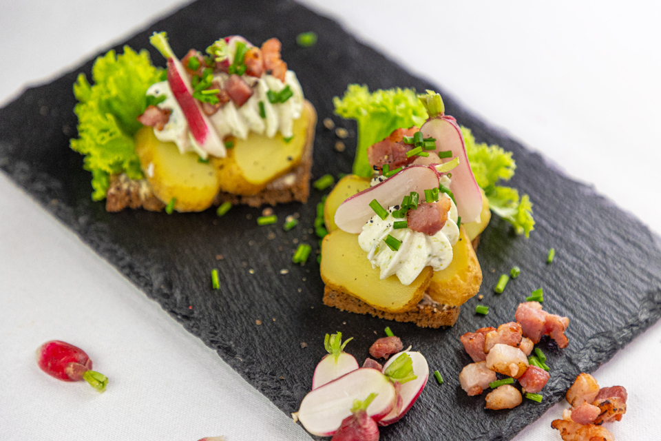 Kartoffelmad anrettet med rygeostcreme, radiser og bacon